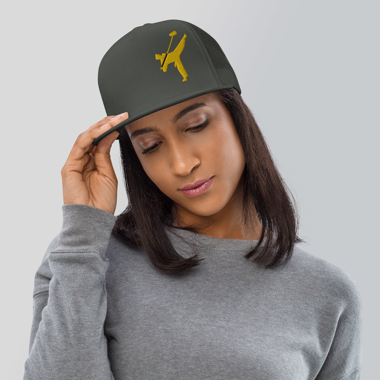 Art Form Gold Boom operator Mesh Snapback Cap. Front view of a woman wearing a charcoal coloured cap with a gold colour graphic of a martial arts fighter, kicking up into the air, holding a boom microphone.