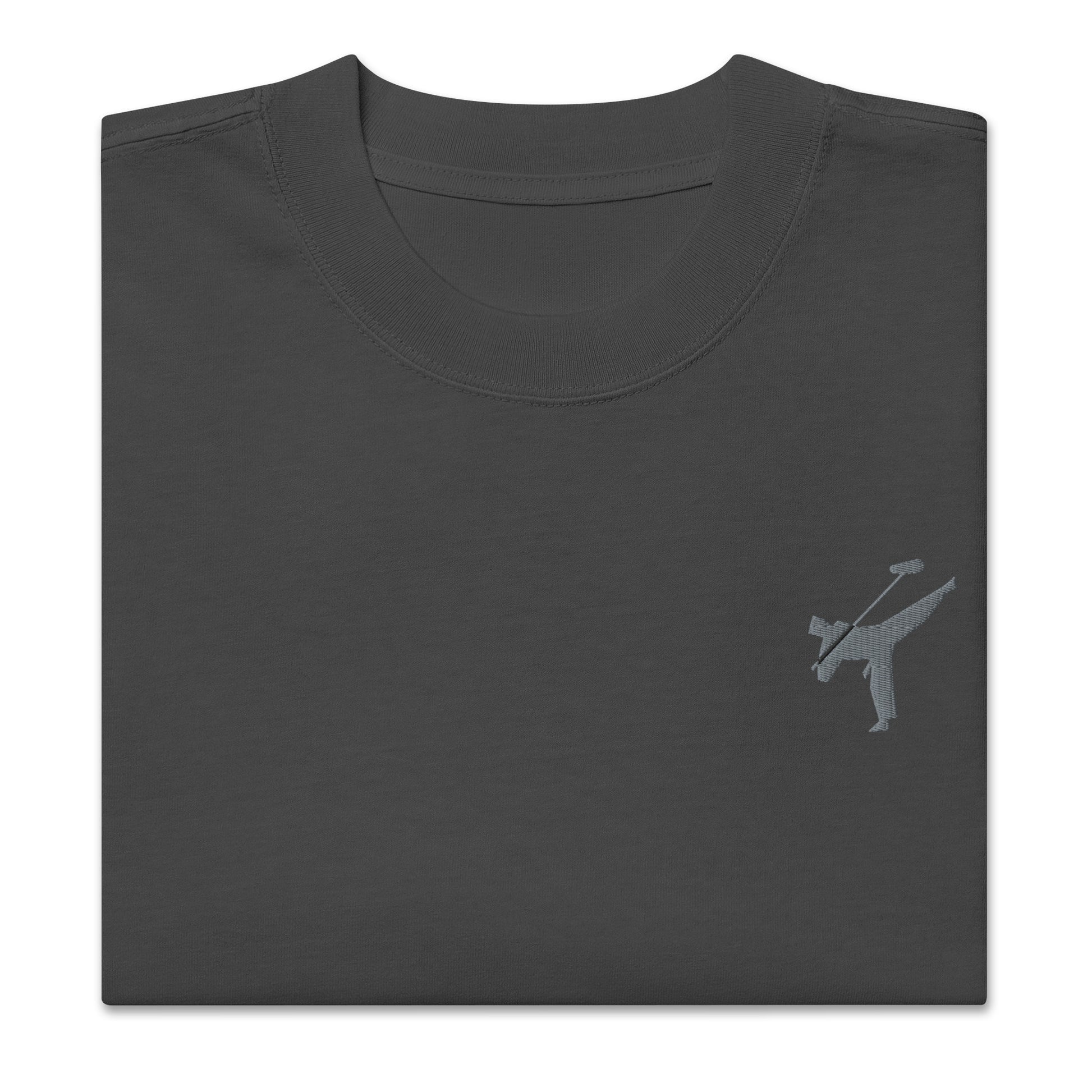 Art Form Boom Icon embroidered T-shirt, close up front view of folded faded black colour t-shirt with an embroidered martial arts boom operator in the top left.